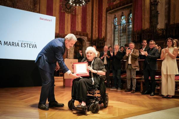 El alcalde Jaume Collboni entrega una placa a Rosa Esteva en el Saló de Cent del Ayuntamiento de Barcelona